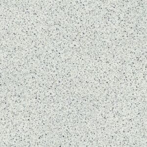 Moduleo Roots Lugano Terrazzo Effect luxury vinyl tile featuring a light base with scattered grey, blue and amber flecks in a classic terrazzo pattern