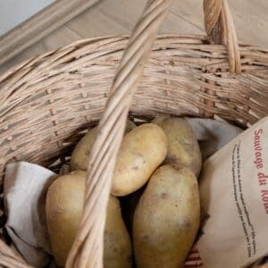 Detail of Quick-Step Classic Havana Oak Natural laminate flooring with basket of potatoes in kitchen setting