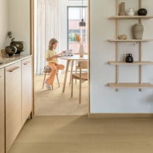 Kitchen and dining space with Quick-Step Capture Beige Varnished Oak flooring and wooden shelving