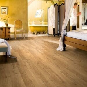 Elegant bedroom with Quick-Step Classic Oak Natural laminate flooring and rustic wooden beams