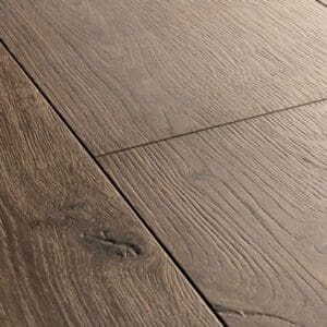 Close-up of Quick-Step Brushed Oak Brown laminate flooring showing detailed wood grain texture
