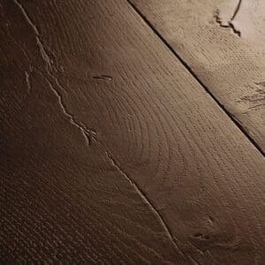 Close-up of Quick-Step Waxed Oak Brown laminate showing detailed wood grain texture
