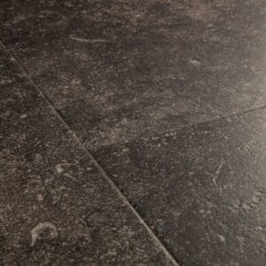 Close-up of Quick-Step Fumed Bluestone laminate flooring showing detailed stone texture and speckled pattern