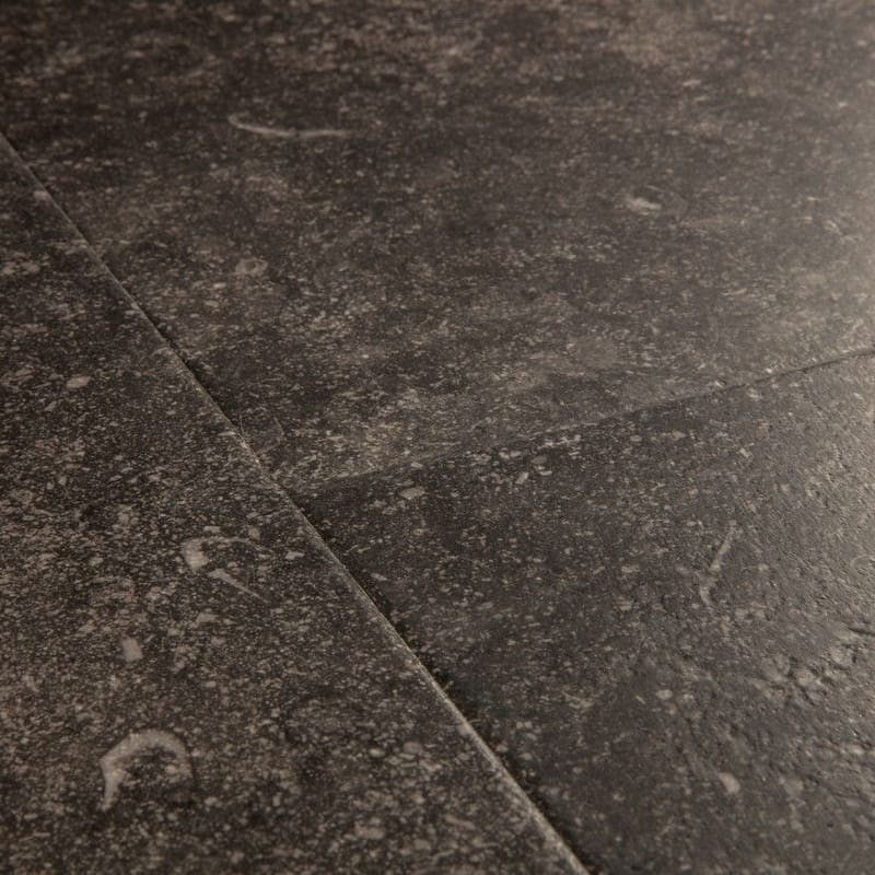 Close-up of Quick-Step Fumed Bluestone laminate flooring showing detailed stone texture and speckled pattern