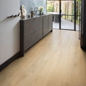 Bathroom with Quick-Step Capture Brushed Oak Natural laminate flooring and stylish blue vanity unit