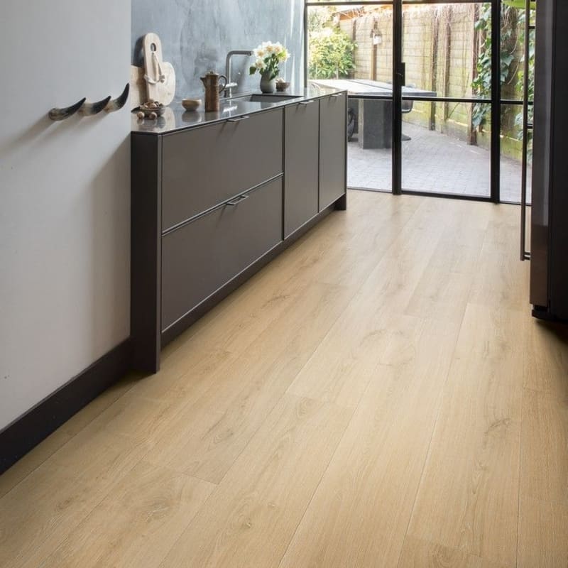 Bathroom with Quick-Step Capture Brushed Oak Natural laminate flooring and stylish blue vanity unit