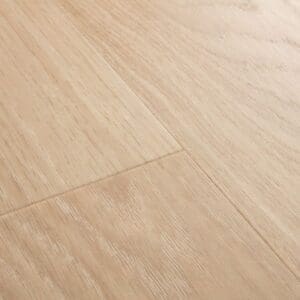 Detailed view of Quick-Step Alpha Bloom Pure Oak Blush vinyl flooring showing plank joints and natural oak pattern
