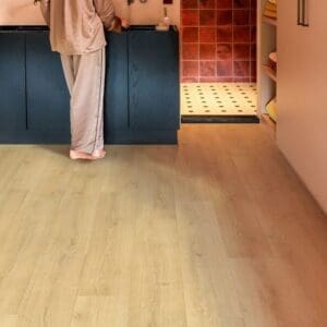 Person standing on Quick-Step Capture Brushed Oak Natural laminate flooring in bathroom with stylish vanity unit