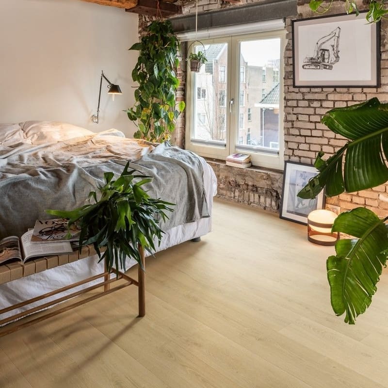 Bedroom with exposed brick walls and wooden beams featuring Quick-Step Capture Brushed Oak Natural laminate flooring