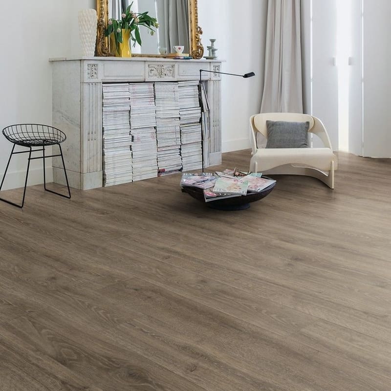 Living room with Quick-Step Majestic Woodland Oak Brown laminate flooring installed, featuring elegant furniture and gold-framed mirror