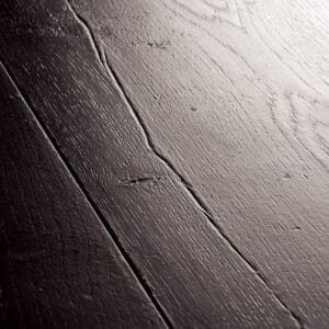 Close-up of black laminate flooring showing wood grain pattern and texture