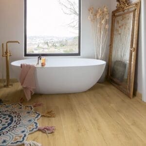 Quick-Step Capture Brushed Oak Warm Natural laminate flooring in a kitchen with a person in blue dress