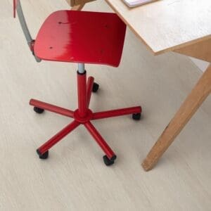 Home office with wooden desk, red chair and light oak vinyl flooring