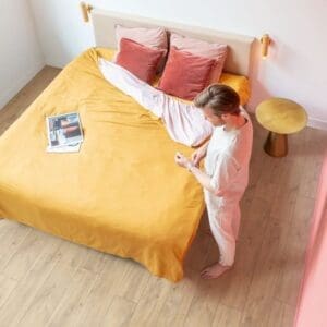 Bedroom setting with Quick-Step Classic Havana Oak Natural laminate flooring and yellow bedding