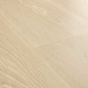 Close-up of Quick-Step Frosty Beige Oak laminate showing water droplets demonstrating waterproof properties