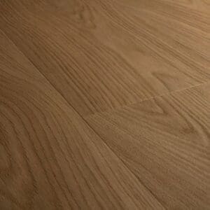 Close-up of Quick-Step Cocoa Oak vinyl flooring showing natural wood grain texture and warm brown tones