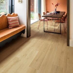 Quick-Step Capture Brushed Oak Warm Natural laminate flooring with person playing guitar and writing