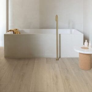 Minimalist space with Quick-Step Brushed Oak Beige laminate flooring and stone accent table