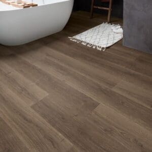 Bathroom with freestanding tub and wooden ladder showing Quick-Step Brushed Oak Brown laminate flooring