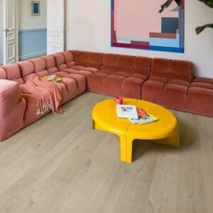 Coastal-style interior with surfboard and white walls showcasing Quick-Step Soft Oak Medium flooring