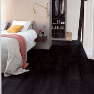 Bedroom interior with black laminate flooring, white bed and built-in wardrobe