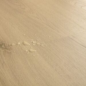 Close-up of Quick-Step Raw Oak Laminate showing water droplets demonstrating waterproof properties