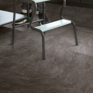 Kitchen with Quick-Step Muse Grey Slate Laminate flooring and person standing on step stool