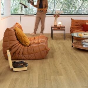 Quick-Step Capture Brushed Oak Warm Natural laminate flooring in a living room with leather seating