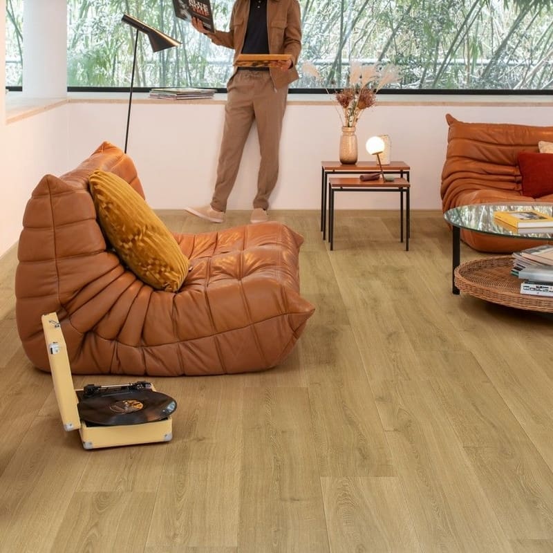 Quick-Step Capture Brushed Oak Warm Natural laminate flooring in a living room with leather seating