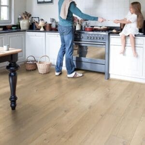 Family kitchen with white cabinets and Quick-Step Soft Oak Medium laminate flooring
