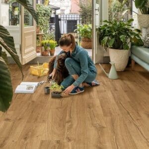 Bright sunroom with plants featuring Quick-Step Impressive Classic Oak Natural laminate flooring