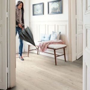 Elegant entryway with Quick-Step Impressive Soft Oak Light laminate flooring, white walls and wooden bench