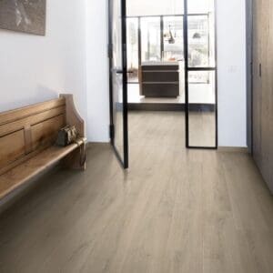 Modern pink-walled room with Quick-Step Brushed Oak Beige laminate flooring and matching chair