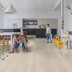 Open plan kitchen and living area with Quick-Step Majestic Valley Oak Light Beige laminate flooring showing family-friendly durability