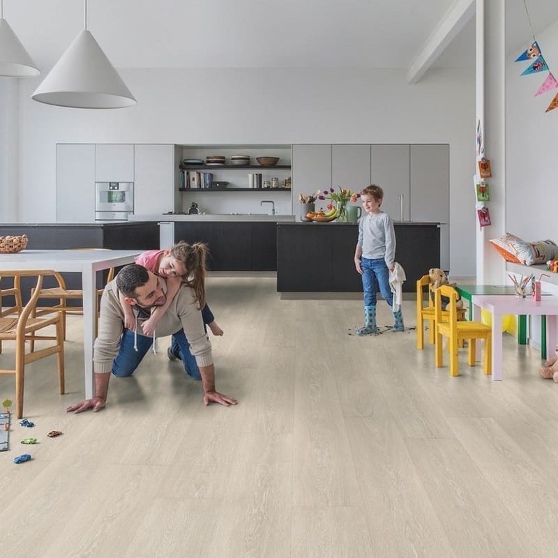 Open plan kitchen and living area with Quick-Step Majestic Valley Oak Light Beige laminate flooring showing family-friendly durability