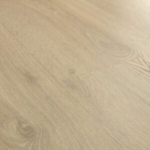 Close-up view of Quick-Step Classic Sandy Greige Oak laminate flooring showing natural wood grain pattern and texture