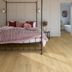 Quick-Step Capture Brushed Oak Warm Natural laminate flooring in a cabin-style living room with wood stove