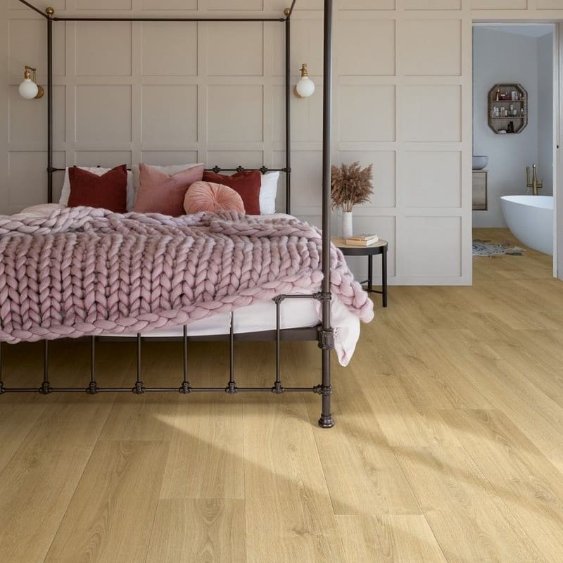Quick-Step Capture Brushed Oak Warm Natural laminate flooring in a cabin-style living room with wood stove