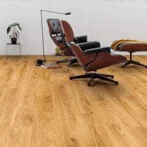 Quick-Step Alpha Blos Classic Oak Natural vinyl flooring installed in a modern living room with designer furniture
