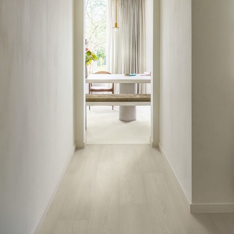 White Premium Oak laminate flooring installed in a bright hallway leading to a dining area