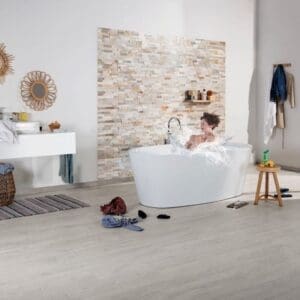Modern bathroom with light grey laminate flooring and freestanding bathtub