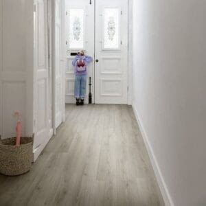 Quick-Step Alpha Bloom Botanic Grey vinyl flooring in hallway setting with white walls