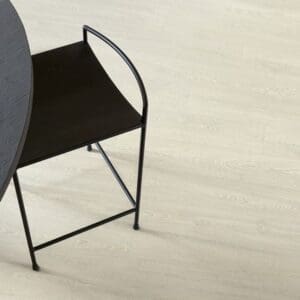 Quick-Step Impressive Ultra Patina Classic Oak Light laminate flooring in a dining area with black furniture showing practical application