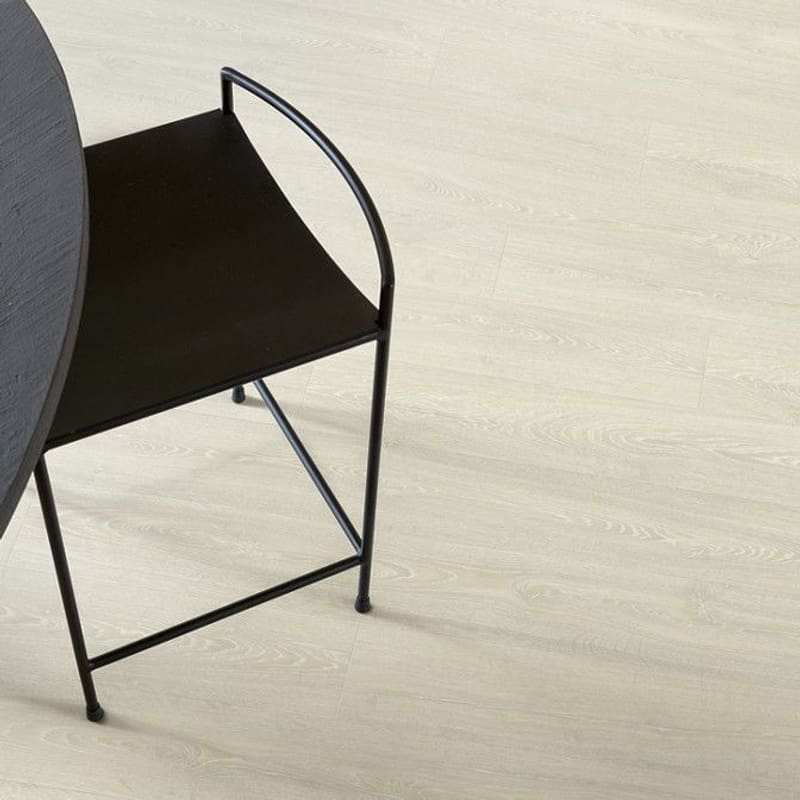Quick-Step Impressive Ultra Patina Classic Oak Light laminate flooring in a dining area with black furniture showing practical application