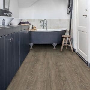 Bathroom with Quick-Step Majestic Woodland Oak Brown laminate flooring installed, showing waterproof performance in wet areas