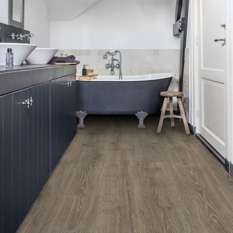 Bathroom with Quick-Step Majestic Woodland Oak Brown laminate flooring installed, showing waterproof performance in wet areas
