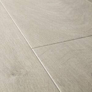 Close-up of Quick-Step Impressive Ultra Soft Oak Grey laminate flooring showing beveled edges and plank joints