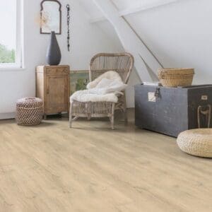 Attic room with Quick-Step Majestic Woodland Oak Beige laminate flooring installed, featuring natural light and rustic furniture